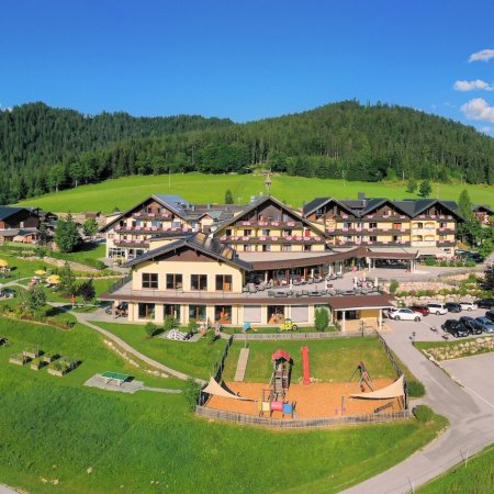 Hotelanlage mit Spielplatz, Pools und Liegewiese in alpiner Panoramalage