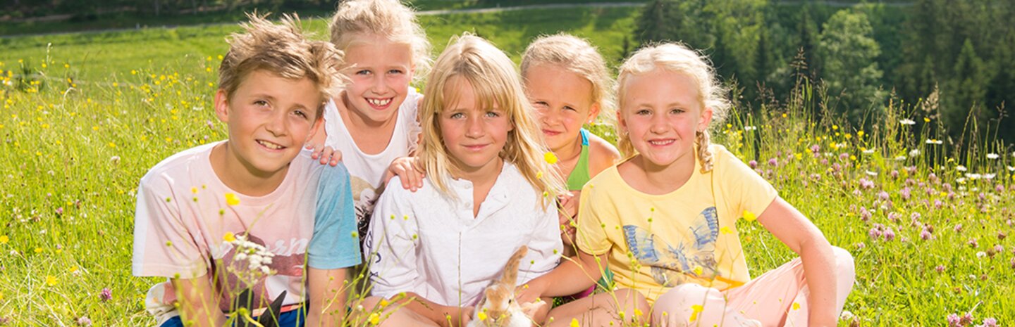 Kinder auf einer blühenden Blumenwiese