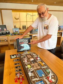 Älterer Herr zeigt ein Krimispiel im Hotel.