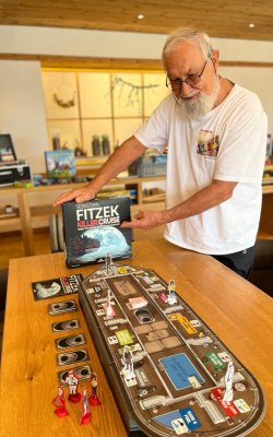 Älterer Herr zeigt ein Krimispiel im Hotel.