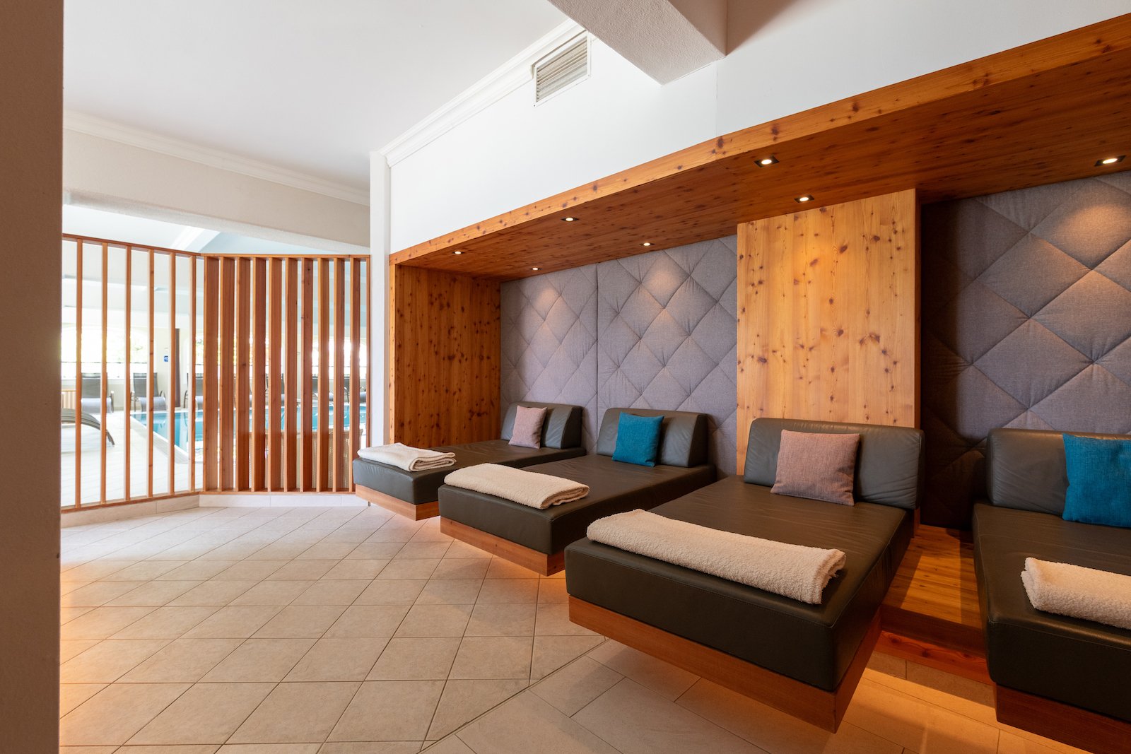 Ruheraum mit Blick auf das Hallenbad und gemütlichen Liegen