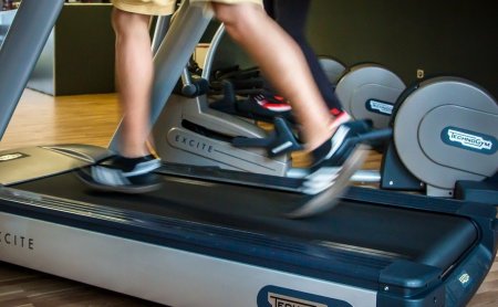 Beine in Bewegung auf einem Laufband im Fitnessraum von Technogym