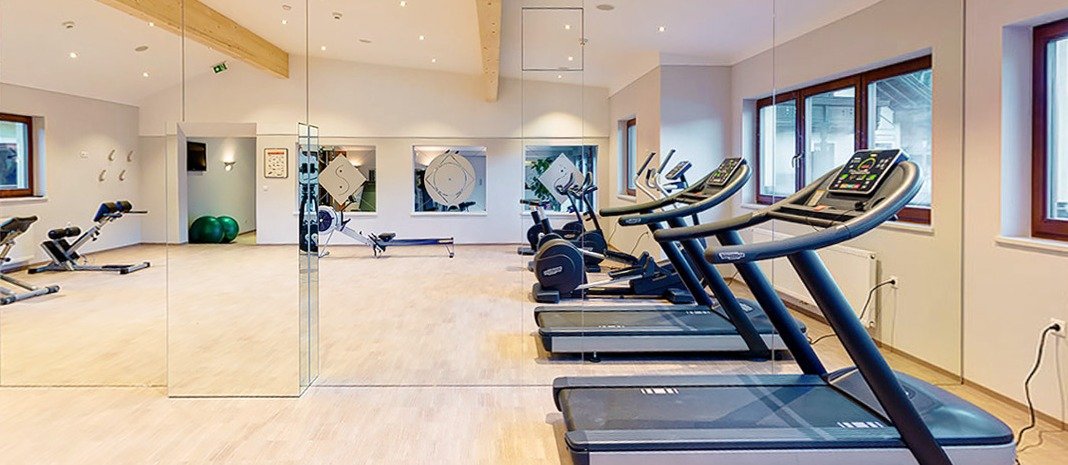 Fitnessraum mit Spiegelwand und Technogym-Geräten