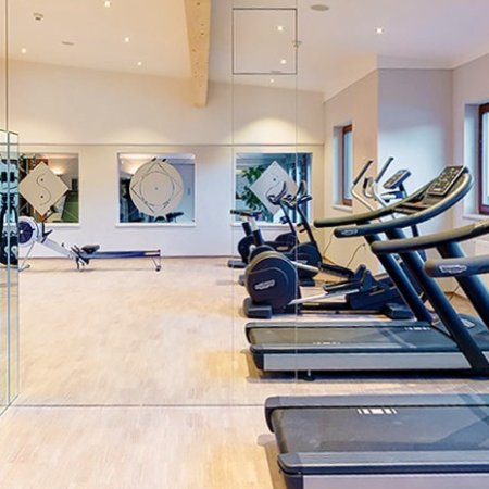 Fitnessraum mit Spiegelwand und Technogym-Geräten