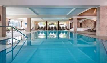 Blick über das ruhige Hallenbad mit Relaxliegen im Hintergrund