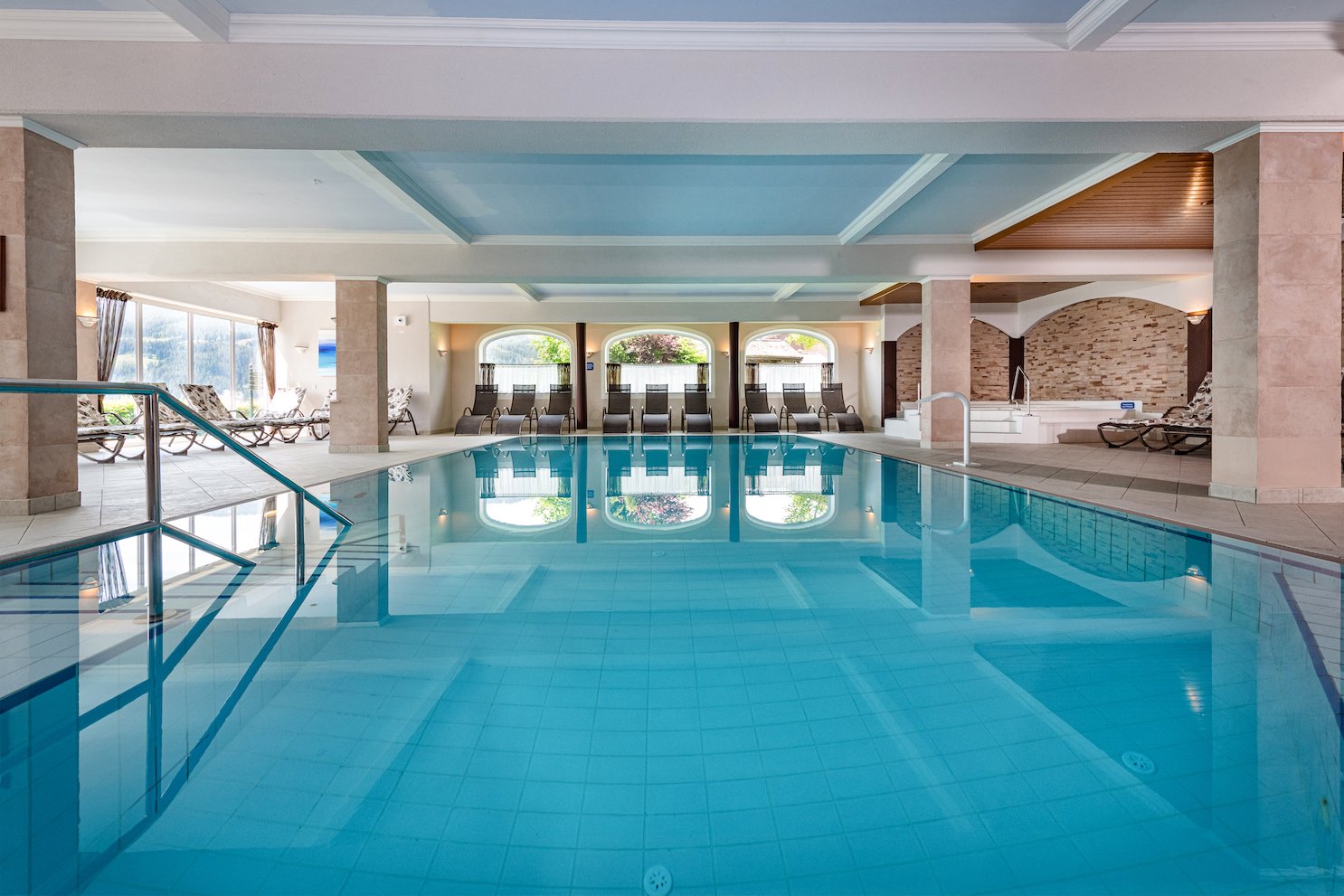 Blick über das ruhige Hallenbad mit Relaxliegen im Hintergrund