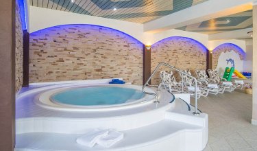 Whirlpool mit Einstieg und Blick auf Liegebereich und Planschbecken
