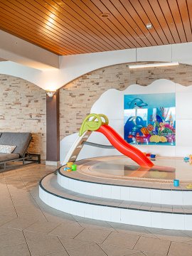 Kinderbecken mit Rutsche und buntem Wasserspielzeug