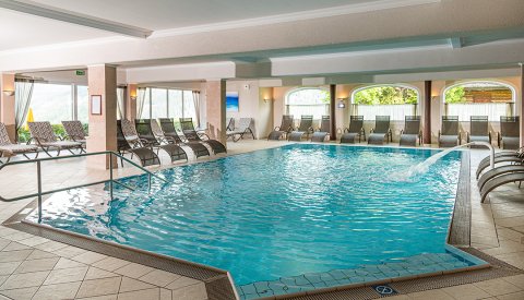 Hallenbad mit Massagedüse und vielen Liegestühlen