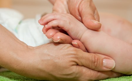 Baby bekommt Massage auf grünem Handtuch