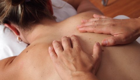 Nahaufnahme einer Rückenmassage im Wellnessbereich.