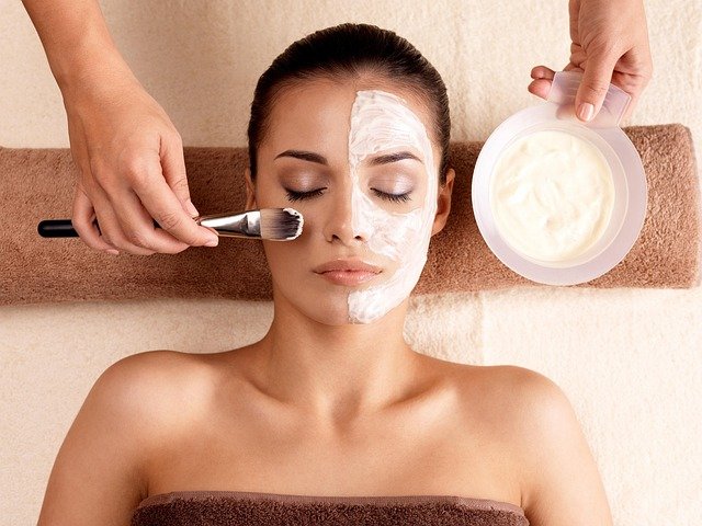 Frau bekommt eine Gesichtsmaske im Spa aufgetragen.