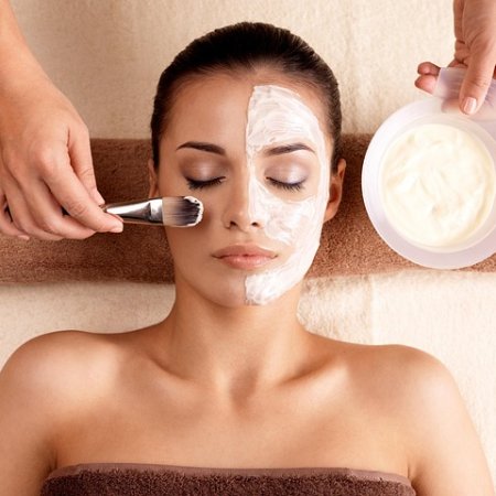 Frau bekommt eine Gesichtsmaske im Spa aufgetragen.