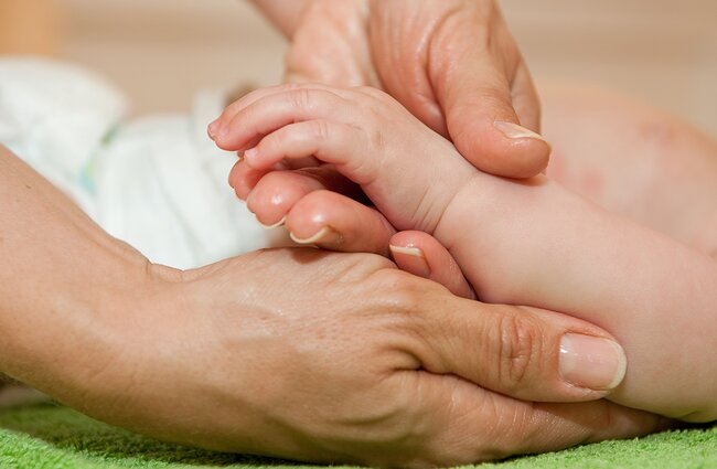 Detailaufnahme der Hände bei einer Babymassage