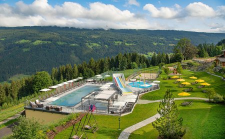 Panoramablick auf Poollandschaft und Spielbereich in den Bergen