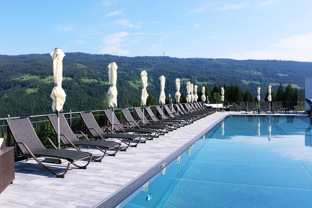 Poolterrasse mit Liegestühlen und Blick auf die Berge