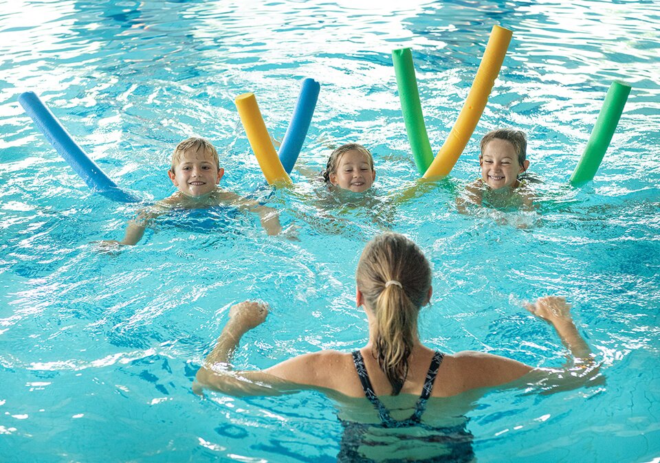 Kinder lernen Schwimmen im Hallenbad