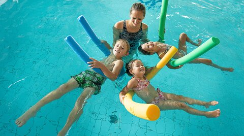 Kinder beim Schwimmkurs im Hallenbad