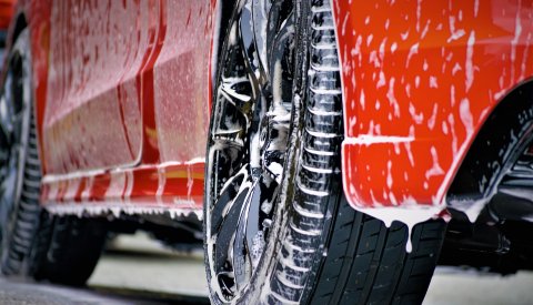 Rotes Auto wird mit Schaum gereinigt