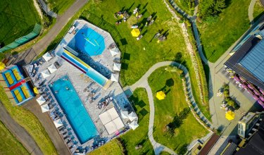 Grundriss mit Pool, Wasserrutschen, Spielbereich und Liegewiese mit Sonnenschirmen