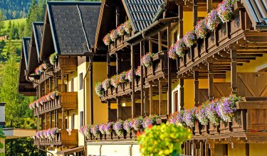 Blumengeschmückte Holzbalkone am Hotel in traditioneller Alpenarchitektur