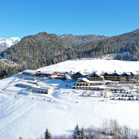 Hotelanlage mit Skipiste im Hintergrund und Blick auf das Dachsteinmassiv