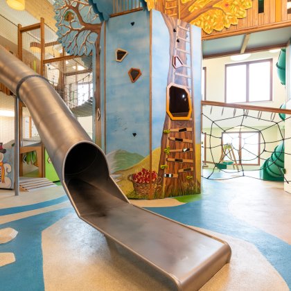 Gemütlicher Indoor-Spielbereich mit Kletterturm, Rutsche und Kletternetzen