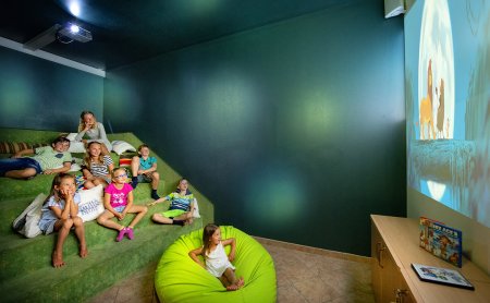 Kinder sehen gemeinsam einen Film im gemütlichen Kinoraum