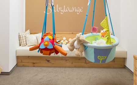 Gemütliche Babylounge mit Spielzeug, Hängesitzen und Sitzgelegenheiten