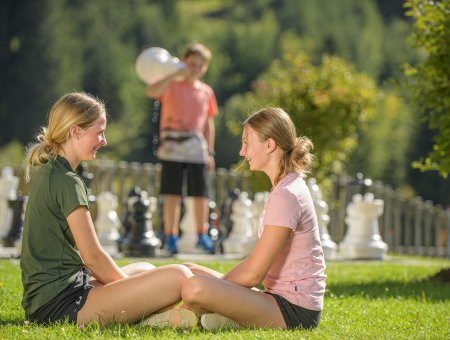 Kinder spielen auf einer großen Schachspielfläche im Freien