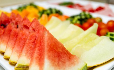 Frisch geschnittene Melonen und Obst, darunter Wassermelone und Honigmelone.