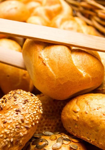 Korb mit verschiedenen Brötchen, einige mit Sesam und Kürbiskernen.