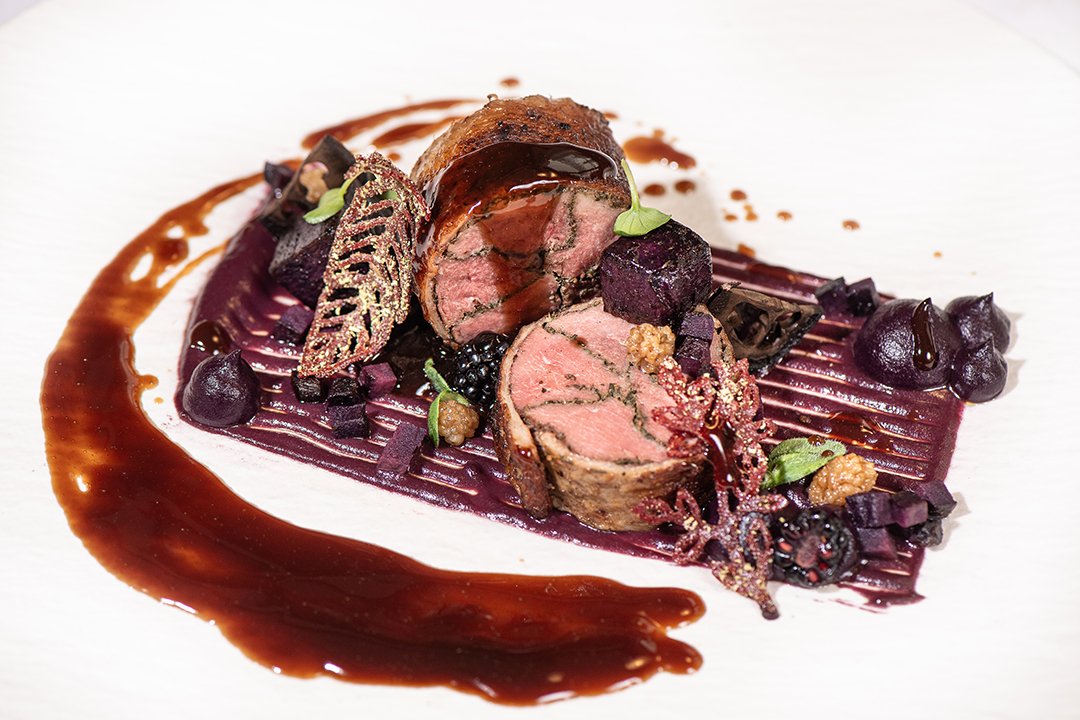 Rinderfilet im Blätterteigmantel, serviert mit Beeren und Sauce.