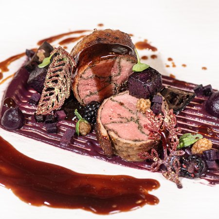 Rinderfilet im Blätterteigmantel, serviert mit Beeren und Sauce.