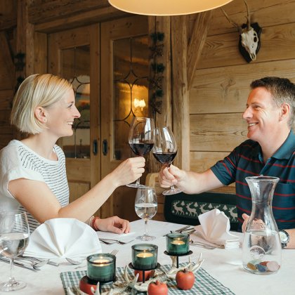 Ein Paar stößt mit Weingläsern an und genießt den Abend in einem gemütlichen Restaurant.