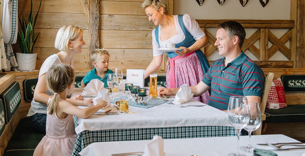 Kellnerin serviert einer Familie Essen