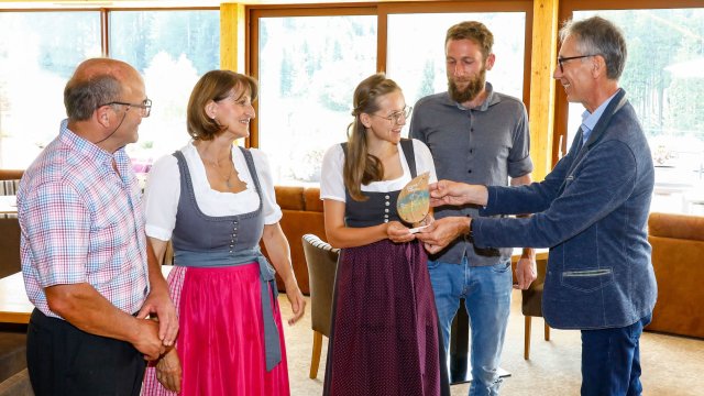 Gruppe von Personen in Trachten erhält eine Auszeichnung.