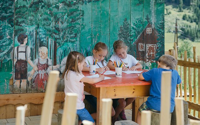 Kinder beim Malen vor dem Hexenhaus