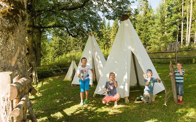 Kinder spielen bei den Indianerzelten