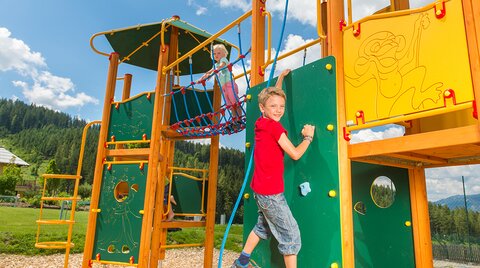 Kinder beim Klettern auf dem Outdoor-Spielplatz
