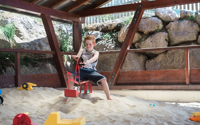 Kind beim Baggern im Sandspielhaus