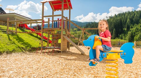 Kind beim Schaukeln auf dem Outdoor-Spielplatz