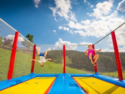 Zwei Kinder springen am Riesentrampolin im Freien