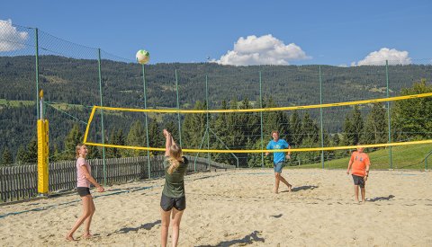 Kinder spielen Beachvolleyball.