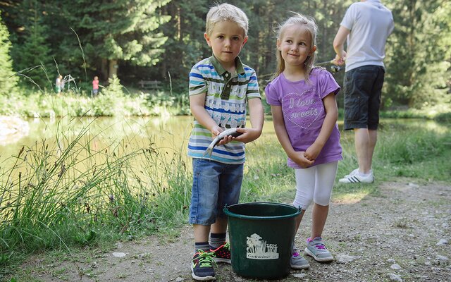 Kinder mit einem Eimer voll geangelter Fische