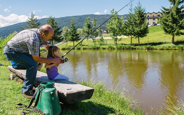 Gastgeber Peter zeigt einem Kind wie man fischt