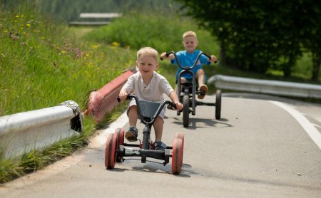 Zwei Jungs fahren mit Go-Karts auf einer abgesicherten Strecke