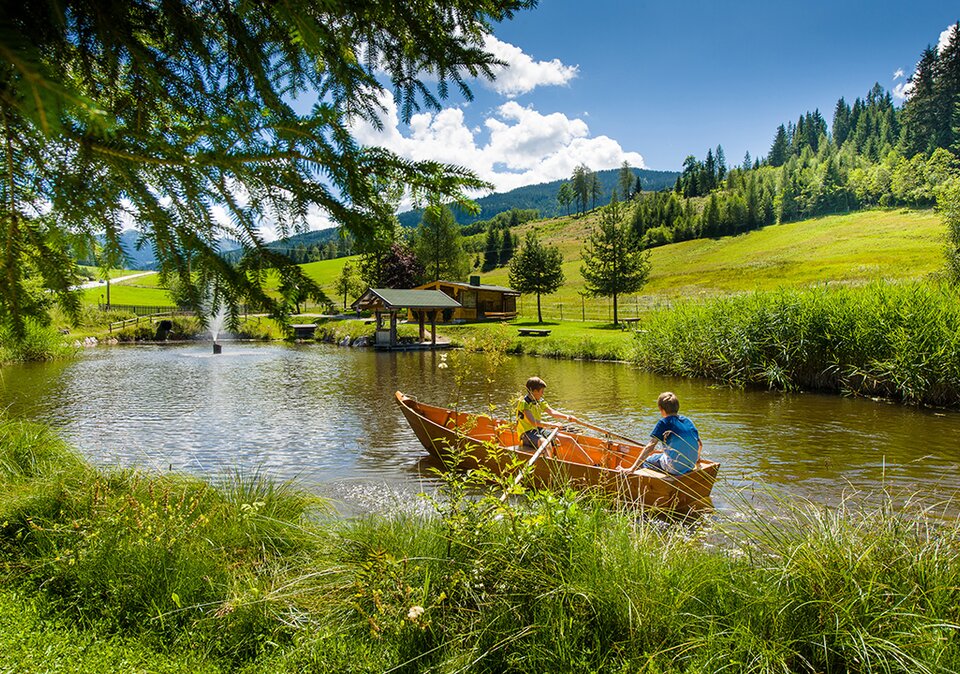 Kinder im Paddelboot auf dem Teich