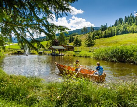 Kinder im Paddelboot auf dem Teich