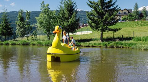 Kinder in der Tretbootente am Teich